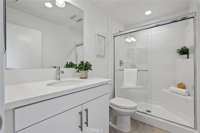 bathroom with vanity, an enclosed shower, and toilet