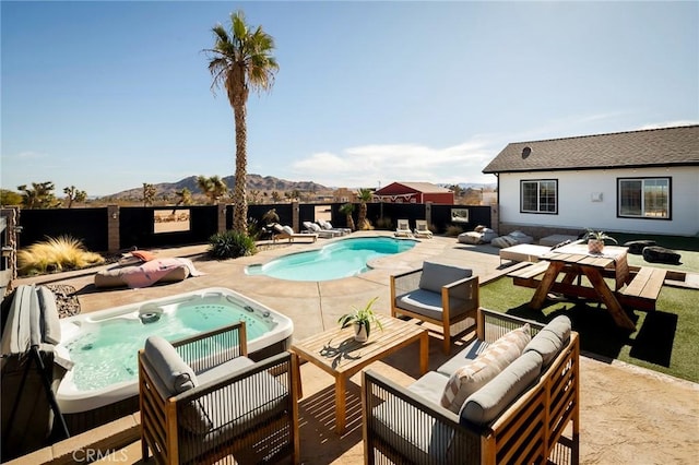 view of swimming pool featuring a fenced backyard, an outdoor hot tub, a patio area, a mountain view, and an outdoor hangout area