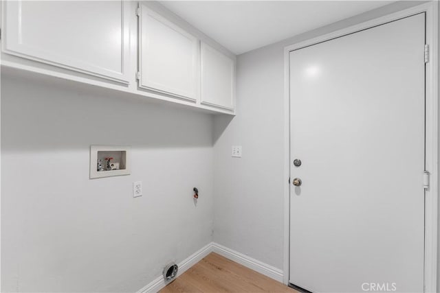 laundry room with hookup for a washing machine, light wood-type flooring, and cabinets