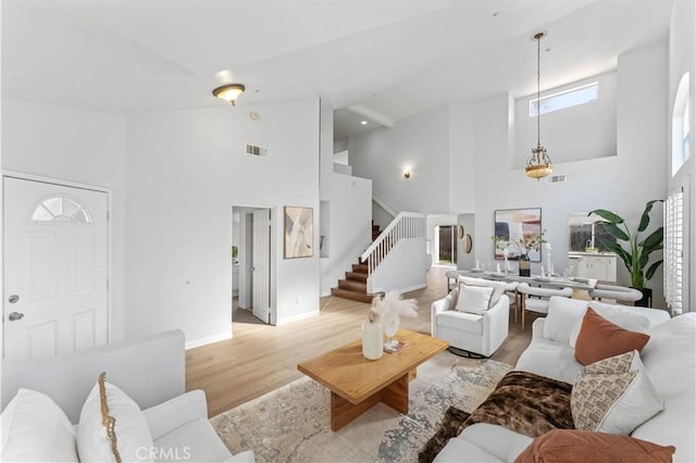 living room with high vaulted ceiling and light hardwood / wood-style floors