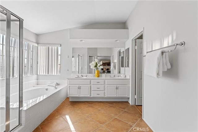 bathroom featuring separate shower and tub, vanity, vaulted ceiling, and tile patterned flooring