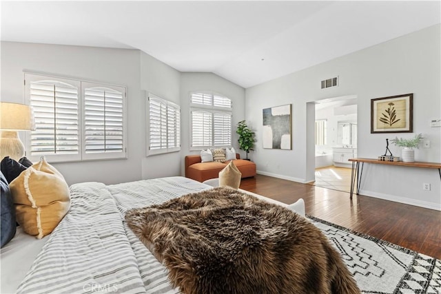 bedroom with lofted ceiling, ensuite bath, and wood-type flooring