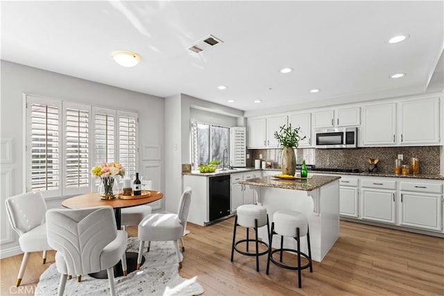 kitchen with sink, white cabinetry, tasteful backsplash, and black appliances