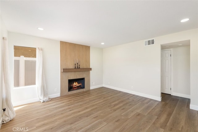 unfurnished living room featuring a fireplace and hardwood / wood-style floors