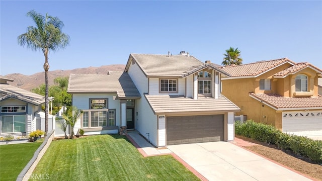 view of front facade with a mountain view, a front lawn, and a garage