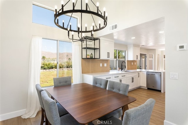 dining space featuring sink, a mountain view, a chandelier, and light hardwood / wood-style flooring