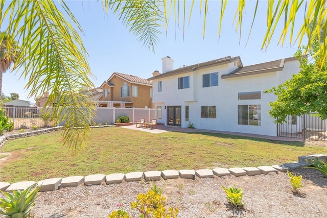 rear view of house featuring a lawn and a patio area