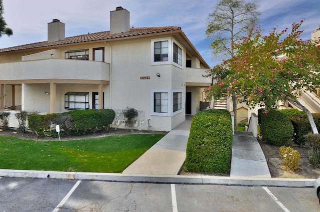 exterior space with a front lawn and a balcony