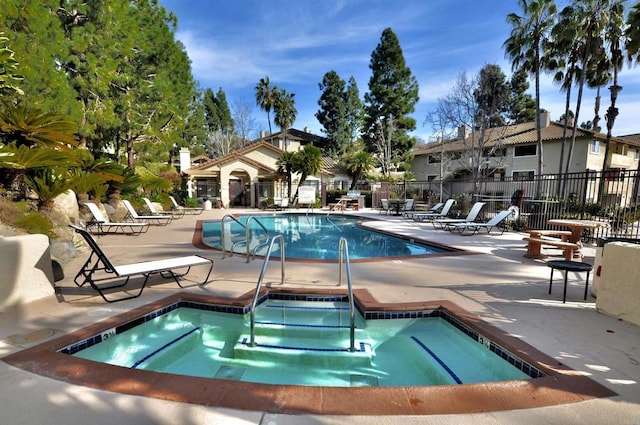 view of swimming pool featuring a community hot tub and a patio area