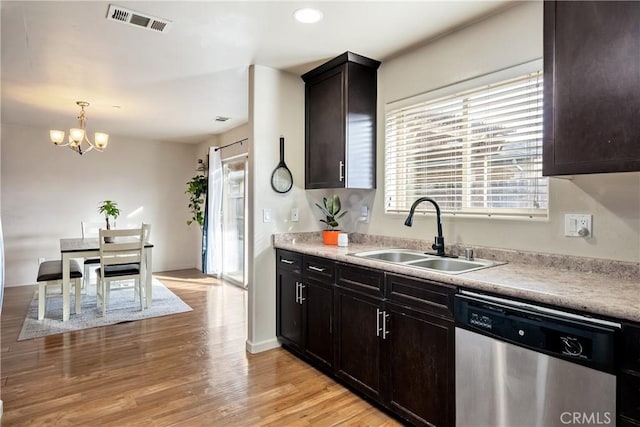 kitchen featuring hanging light fixtures, a notable chandelier, dishwasher, light wood-type flooring, and sink