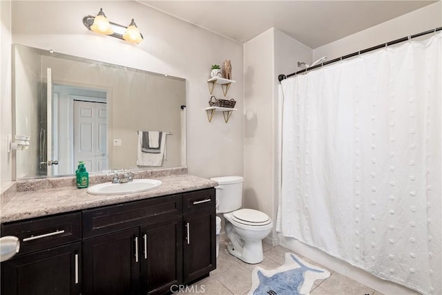 bathroom with tile patterned flooring, vanity, and toilet