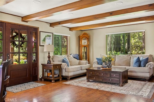 living room with hardwood / wood-style flooring, beam ceiling, and a wealth of natural light