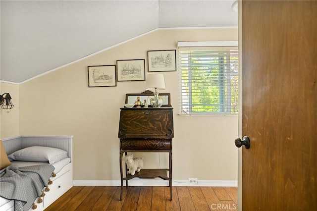 interior space with ornamental molding, hardwood / wood-style flooring, and lofted ceiling