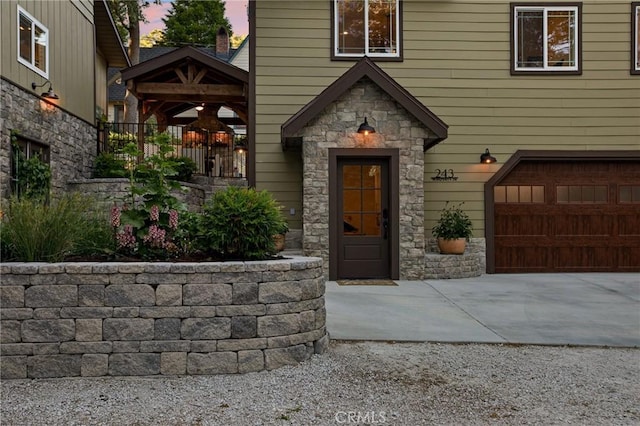 exterior entry at dusk featuring a garage