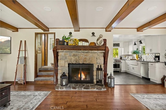 living room with beam ceiling, dark hardwood / wood-style flooring, and a fireplace