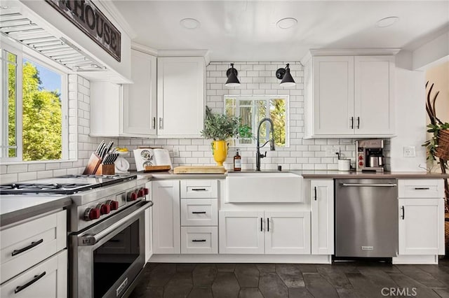 kitchen with white cabinets, appliances with stainless steel finishes, sink, and tasteful backsplash