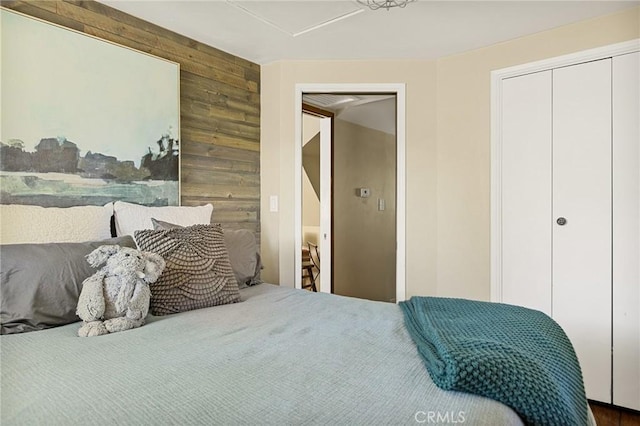 bedroom with a closet and wooden walls