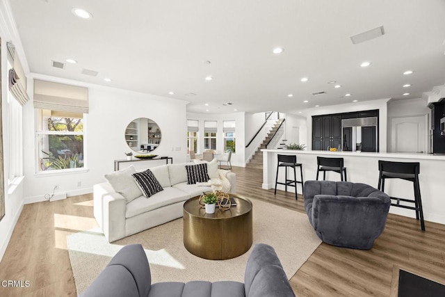 living room featuring light hardwood / wood-style flooring and ornamental molding