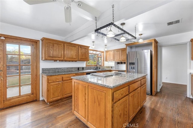 kitchen with sink, light stone counters, a kitchen island, dark hardwood / wood-style floors, and high quality fridge