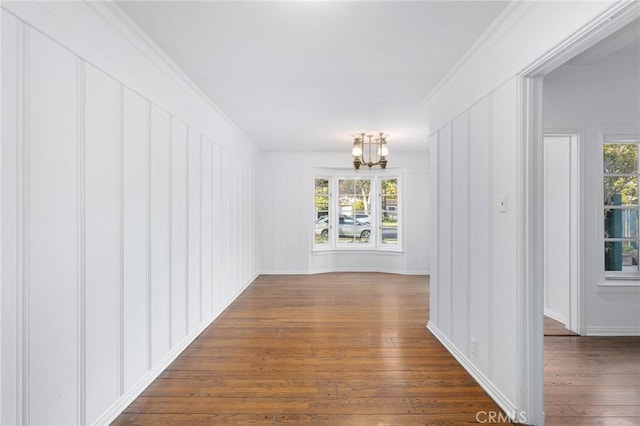 interior space featuring crown molding, an inviting chandelier, and dark hardwood / wood-style flooring