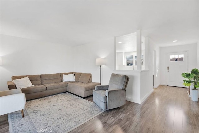 living room with recessed lighting, baseboards, and wood finished floors