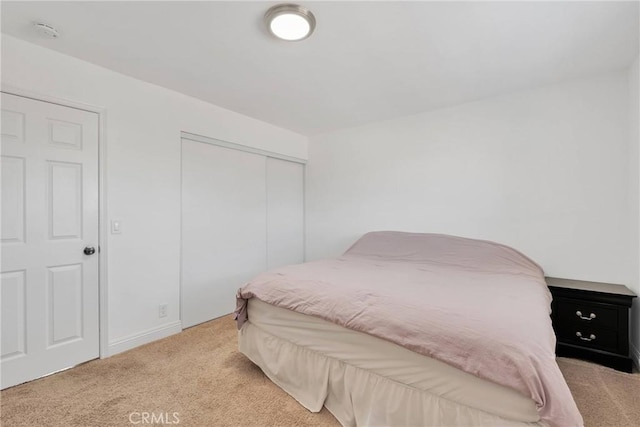 bedroom featuring a closet and light colored carpet