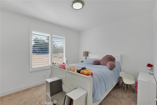 bedroom with light colored carpet and baseboards