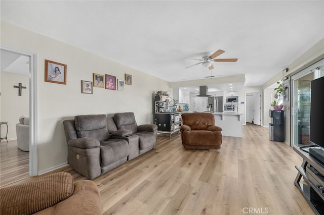 living room featuring ceiling fan and light hardwood / wood-style floors