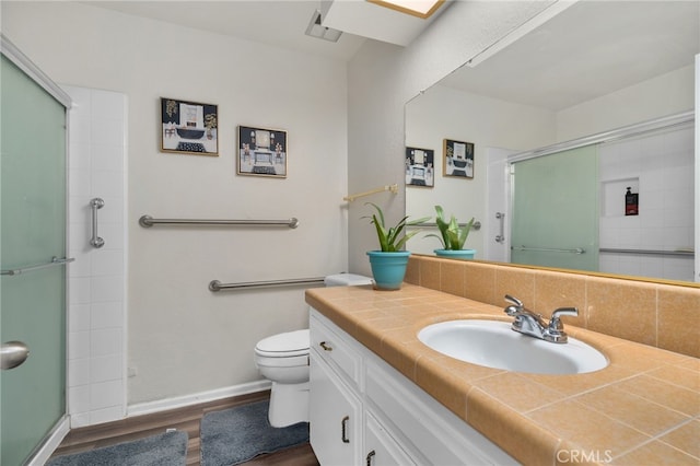 bathroom featuring a shower with door, toilet, hardwood / wood-style flooring, and vanity