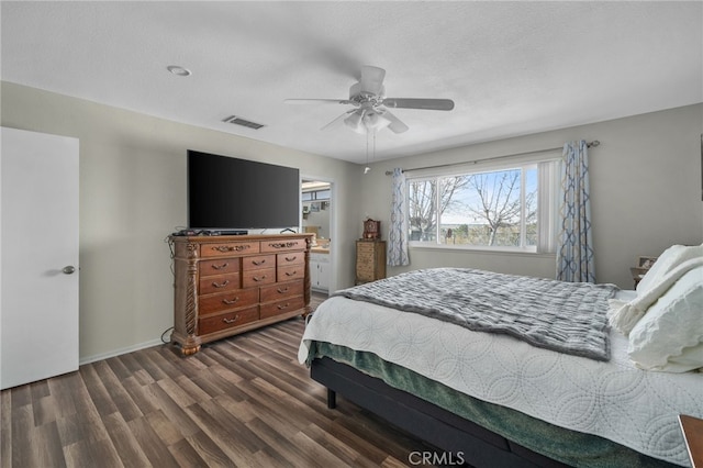 bedroom with ceiling fan, dark hardwood / wood-style flooring, and a textured ceiling