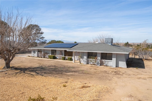 view of front of property with covered porch, roof mounted solar panels, and stucco siding