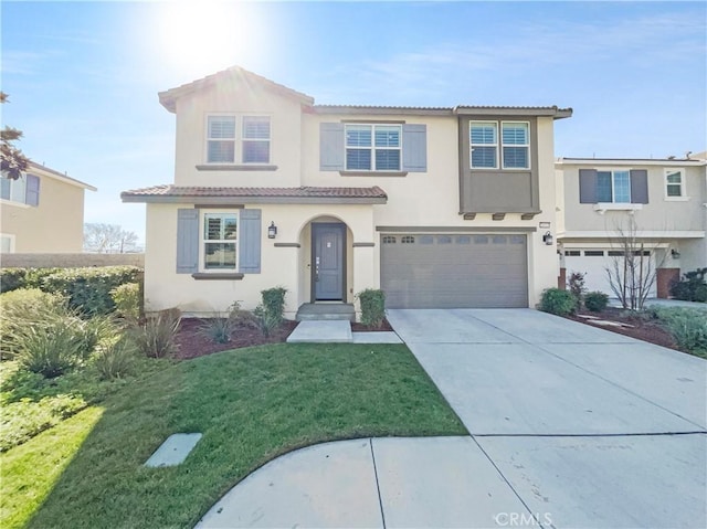 mediterranean / spanish-style house with stucco siding, an attached garage, a front yard, driveway, and a tiled roof