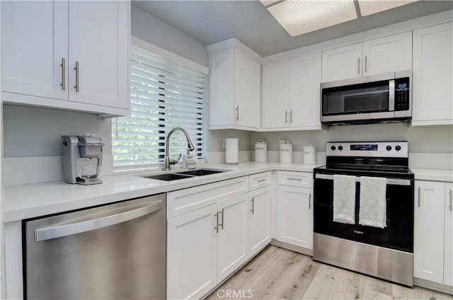 kitchen featuring light hardwood / wood-style floors, white cabinetry, stainless steel appliances, and sink