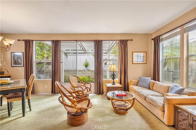 interior space featuring light carpet, an inviting chandelier, and plenty of natural light