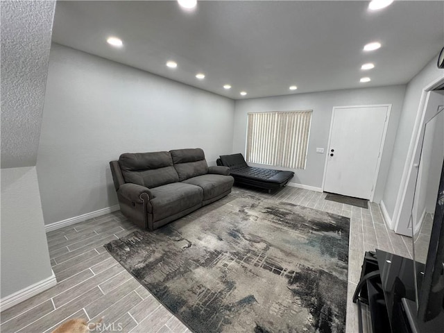 living room with recessed lighting, baseboards, and wood finish floors