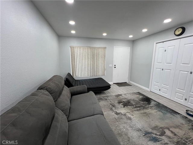 living room with baseboards, wood finished floors, and recessed lighting