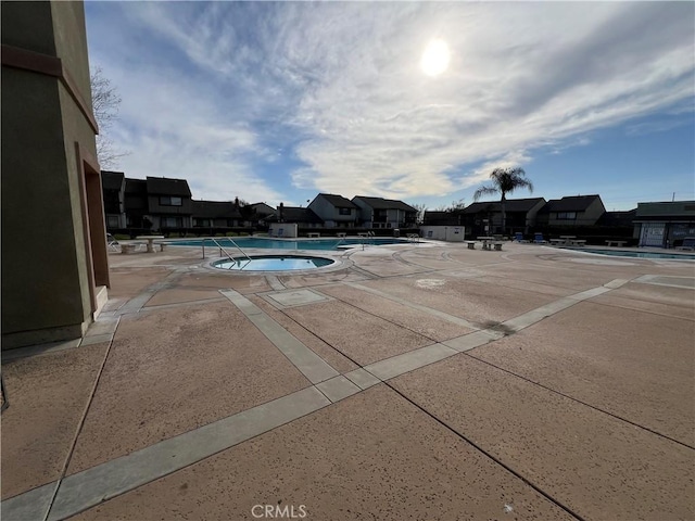 view of swimming pool with a residential view and a community hot tub