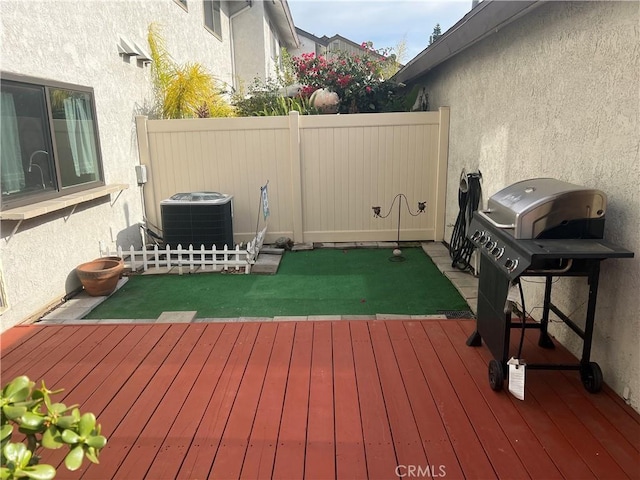 wooden deck with cooling unit, fence, and grilling area