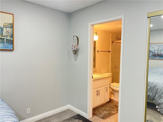 full bath featuring baseboards, vanity, and toilet