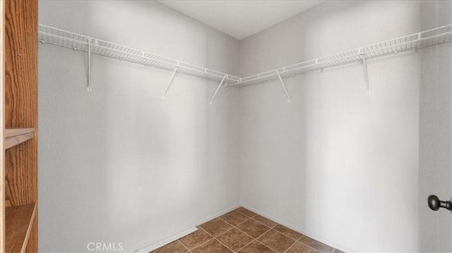 walk in closet featuring dark tile patterned floors