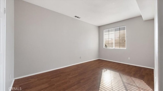 spare room featuring dark wood-type flooring