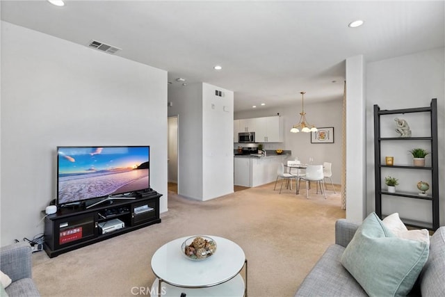 living room with recessed lighting, light colored carpet, and visible vents