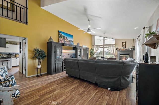 30451 San Pasqual Rd, Temecula, CA 92591 - living area featuring a ceiling fan, wood finished floors, a glass covered fireplace, and baseboards