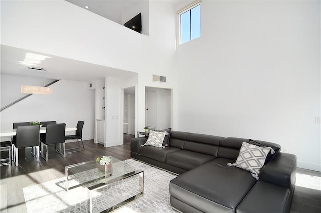 living room with a towering ceiling and hardwood / wood-style floors