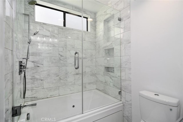 bathroom with bath / shower combo with glass door and toilet