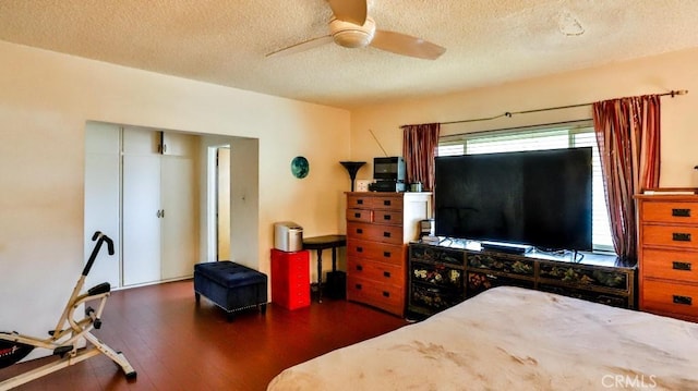 bedroom featuring dark wood-style floors, a textured ceiling, and a ceiling fan