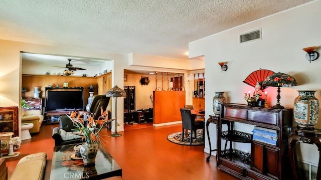 interior space featuring a ceiling fan, visible vents, and a textured ceiling