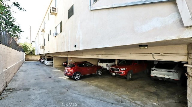 view of car parking featuring a wall mounted AC