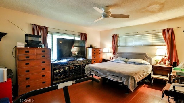 bedroom with a textured ceiling, ceiling fan, and light wood finished floors