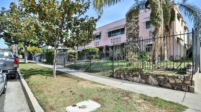 view of home's community with a lawn and fence